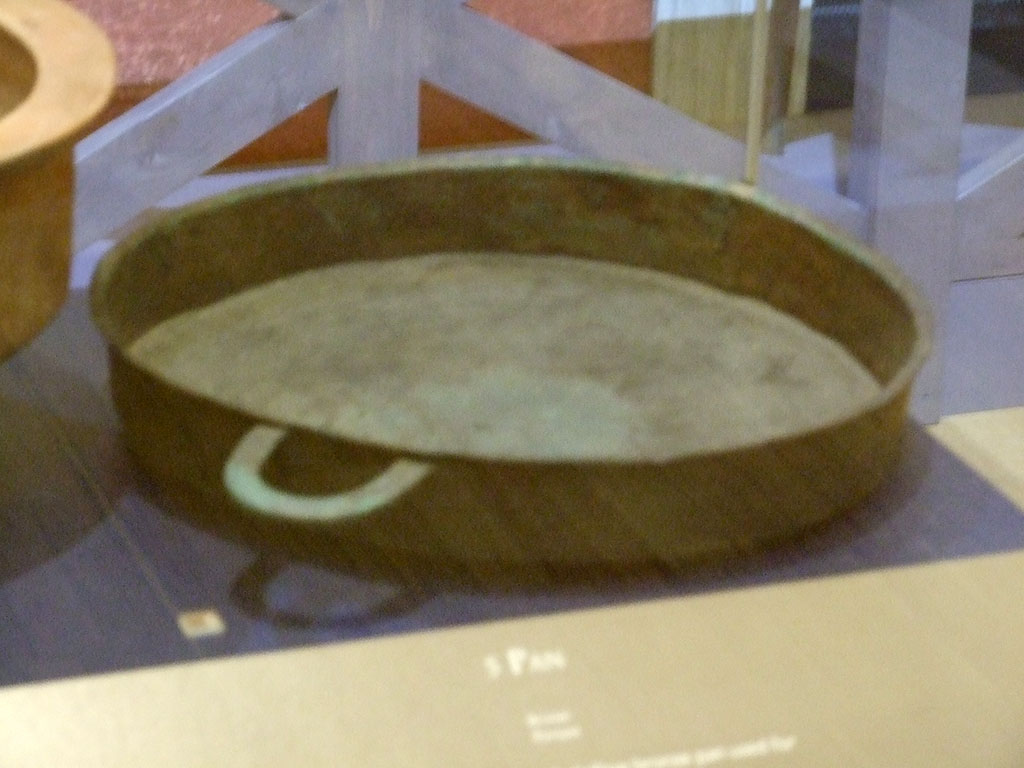 II.9.2 Pompeii. Bronze tegame or pan. SAP 12738. 
Photographed at A Day in Pompeii exhibition at Melbourne Museum. September 2009.

Two bronze statuettes of Apollo and Fortuna with cornucopia and a clay herm of a child Dionysus with panther were also found still in situ in the household lararium.
See Attivit della Soprintendenza: Regio II, Insula 9: Rivista di Studi Pompeiani II, 1988, p. 200.
