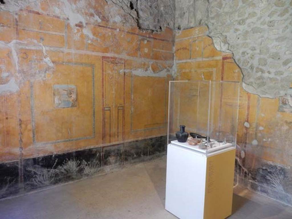II.9.4, Pompeii. May 2018. Room 8, looking towards south-west corner of oecus, with display case with items found.
Photo courtesy of Buzz Ferebee. 
