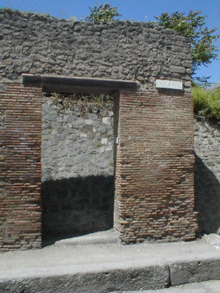 III.1.6 Pompeii. May 2005. Entrance doorway, partly excavated
According to Della Corte, an obscure Praedicinius practiced his unknown commerce or industry here.
He came to this conclusion because of the graffito found on the pilaster on the right -
Popidium adulescentem
Praedicinius rog(at) aed(ilem)    [CIL IV 7608]
See Della Corte, M., 1965.  Case ed Abitanti di Pompei. Napoli: Fausto Fiorentino. (p.342)
According to Garcia y Garcia, there was slight damage to the south-east corner of this insula, when a bomb fell onto the Via dellAbbondanza in 1943. The bomb fell in front of the SE corner of this insula, between III.1.6 and I.XI.7.  See Garcia y Garcia, L., 2006. Danni di guerra a Pompei. Rome: LErma di Bretschneider. (p.51)

