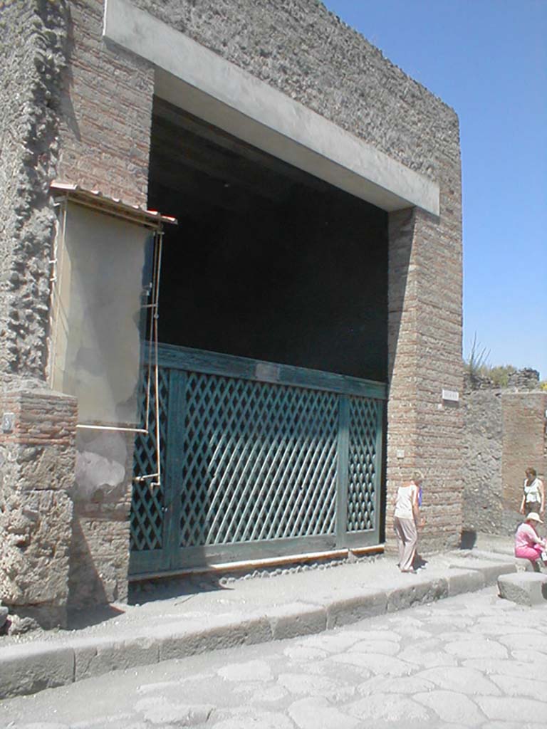 III.3.6 Pompeii. May 2005. Entrance, with reproduction of the original type of doorway gate.
The entrance doorway was almost as wide as the room behind it.  
It was thought this, full of military emblems, weapons, cupboards, etc, was occupied by a military association.
