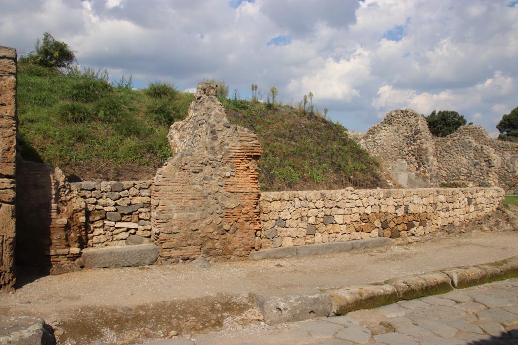 III.7.5 Pompeii, centre right. October 2022. Entrance doorway, with grey lava doorway threshold, on north side of Via dell’Abbondanza.
On the left is the entrance doorway belonging to III.7.4.  Photo courtesy of Klaus Heese

