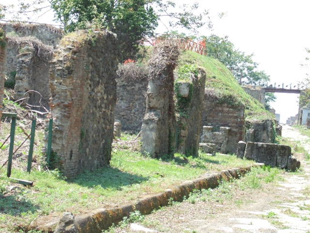 III.11.5 Pompeii. (with green gates). May 2006. Looking west along remainder of Insula III.11 to fountain on Via Nola. 