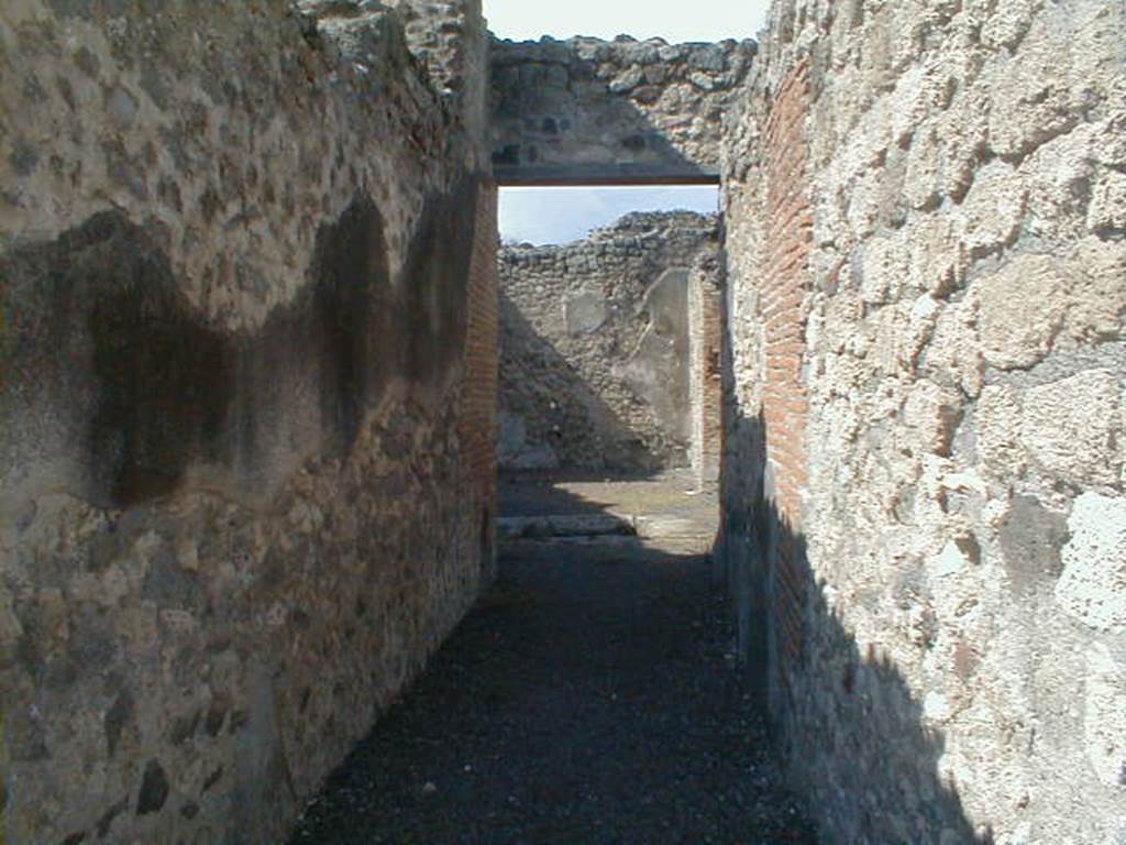 V.1.3 Pompeii. September 2004. Entrance corridor, looking north across atrium towards tablinum.
According to Niccolini –
“This house was preceded by the usual entrance corridor, which leads to the atrium with an impluvium in the centre, there are three cubiculae on the left side of the atrium, and on the right, a passage leading into the following house (at V.1.7) and a very large room.
Facing (on the north side) we find the tablinum with a triclinium on its right, surrounded internally by large masonry seating, which could have been used as the triclinium couches, and to the left from a small corridor going up two steps you reach the kitchen with nearby latrine.
The tablinum, the triclinium, the corridor and kitchen were excavated in 1875.” 
See Niccolini F, 1896. Le case ed i monumenti di Pompei: Volume Quarto: Part 1. Napoli, (p.8, Appendice, Nuovi Scavi dal 1874 a tutto il 1882)
