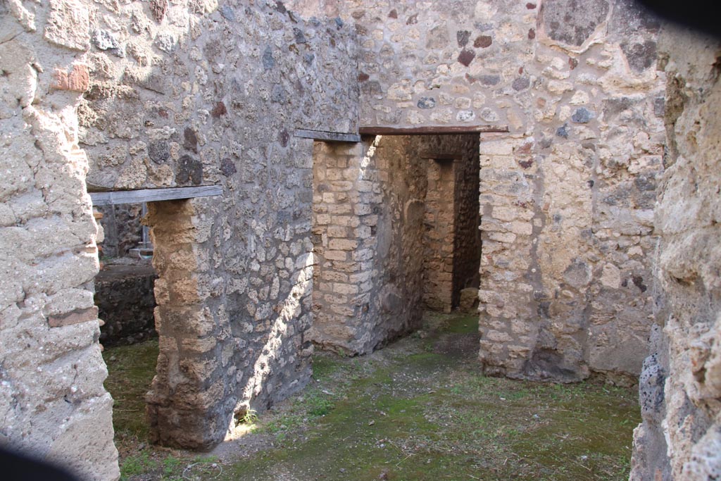 V.1.11 Pompeii. December 2005. Entrance doorway, looking south.
In the east wall, (on the left), are two doorways – 
the nearest into a latrine, the second into the kitchen with a hearth against the east wall and the lararium niche above it.
