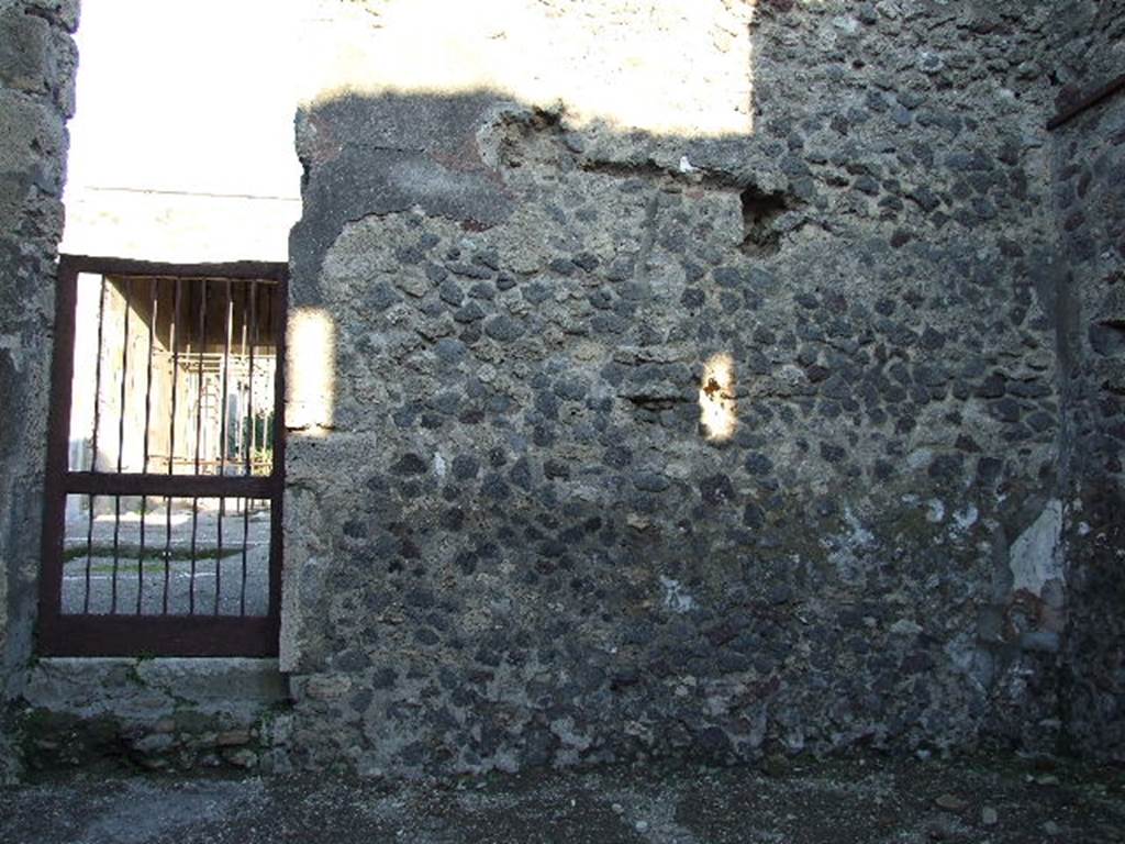 V.1.27 Pompeii. December 2006. East wall of shop, with doorway to atrium of V.1.26. There used to be a staircase leaning against this east wall, but no longer visible.
