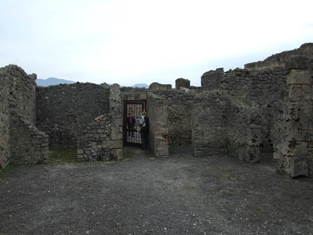 V.2.1 Pompeii. December 2007. Room 1, looking south across the atrium to the entrance.
On the south side of the atrium are the doorways to our rooms 2, on the left, and room 4, on right of entrance corridor.
The doorway to room 5 can be seen on the right.
(BdI, room letters on plan) - Doorway to room u, on left of entrance corridor, room k on right of entrance corridor, room l on right-hand side.
According to Mau, in the distribution of the rooms, this house did not follow the regular scheme but had obeyed the needs of the confined space.  
Around the atrium were three cubicula, (k, l and u), a storeroom or cella penaria (s), and the stairs to the upper floor (n); next to the tablinum and accessible from it were two spacious tricliniums (p and r), of which (r), which had a wide window in its north wall onto the garden could have been called the summer triclinium, and the smaller room with wide entrance (o) could have been used for family dinners.
See Mau, Bullettino dellInstituto di Corrispondenza Archeologica (DAIR), 1885, p.158.

According to PPM,  
The atrium with a similar red zoccolo, divided into compartments, had the middle zone of the walls with raw (rough) plaster.  
The three cubicula (k, l and u) had tripartite walls in panels with vignettes (birds, deer, griffins, only in l a medallion with painted masks was preserved) in k, these were executed more crudely; in u, on the south wall in the lunette was preserved a painted basket from which figs had fallen. 
See Carratelli, G. P., 1990-2003. Pompei: Pitture e Mosaici: Vol. III. Roma: Istituto della enciclopedia italiana, (p.774). 