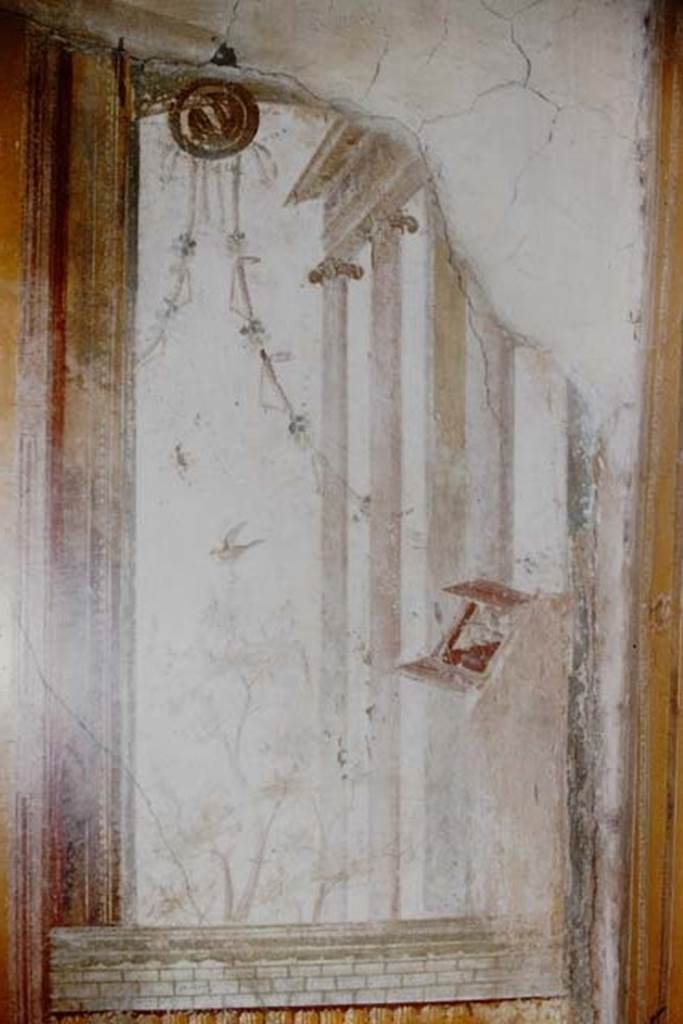 V.2.1 Pompeii. 1959. Room 15, painted panel from south end of east wall.
Photo by Stanley A. Jashemski.
Source: The Wilhelmina and Stanley A. Jashemski archive in the University of Maryland Library, Special Collections (See collection page) and made available under the Creative Commons Attribution-Non Commercial License v.4. See Licence and use details.
j59f0446
According to PPM –
On the east wall of triclinium “r”, at the south end, showing a glimpse through a window, from the top of which hangs an oscillum with garlands, and which was closed at the bottom by a brick masonry, shows a building with Ionic columns, perhaps a temple in front of which was a tree on which a bird flies.
See Carratelli, G. P., 1990-2003. Pompei: Pitture e Mosaici: Vol. III. Roma: Istituto della enciclopedia italiana, p. 794, no. 33.
