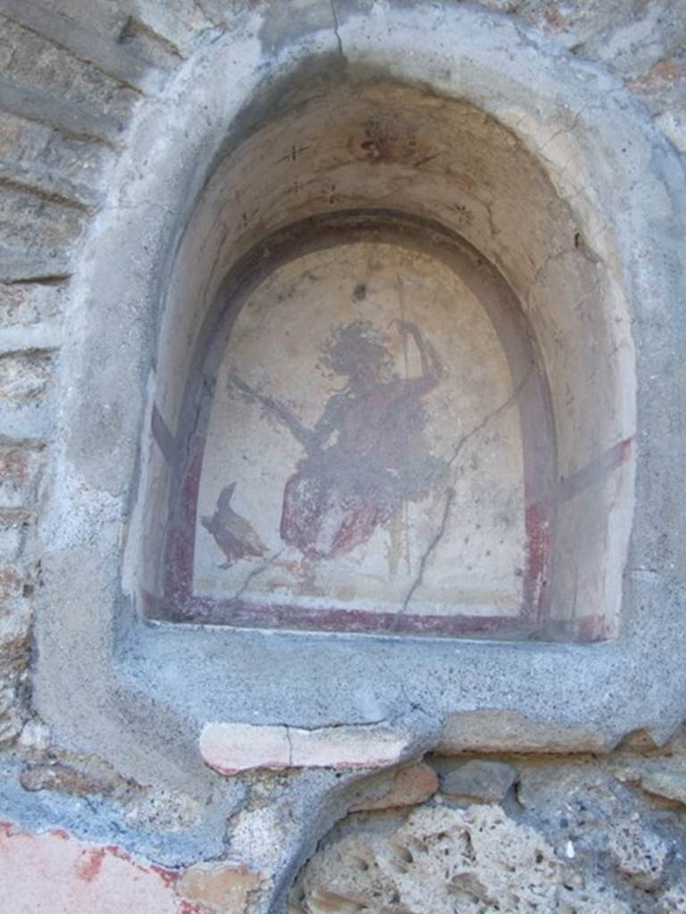 V.2.4 Pompeii. December 2007.  Detail of arched niche on south wall of the atrium to the east of the entrance. See Fröhlich, T., 1991, Lararien und Fassadenbilder in den Vesuvstädten. Mainz: von Zabern. (L42:p.267, T. 35,2).
According to Boyce, the interior was white, outlined with red stripes and on the rear wall was painted the figure of Jupiter. He was sitting on a throne with a green cushion, his feet on a footstool. The upper part of him was naked, the lower wrapped in a reddish mantle. He held a sceptre in his left hand, and a thunderbolt in his right. On his left side, was the eagle gazing up at Jupiter. The arched ceiling of the niche, was painted with yellow, rose and violet stars on a white background.
In the centre was painted the bust of Luna with the whip in her hand, beneath her was a crescent moon.
See Boyce G. K., 1937. Corpus of the Lararia of Pompeii. Rome: MAAR 14. (p.34, no.86 and Pl. 2, 6)

