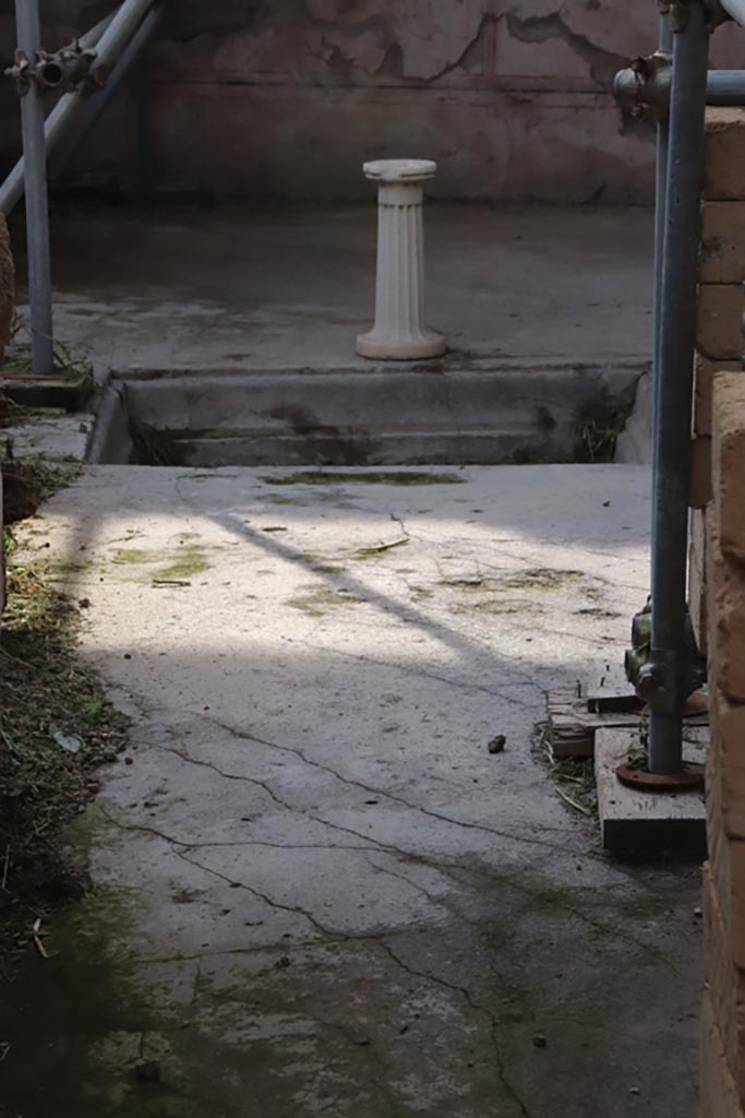 V.2.21 Pompeii. October 2022. 
Looking west across atrium from entrance corridor. Photo courtesy of Klaus Heese.
At the rear of the impluvium, the decorated lower wall of the third room on the west side can be seen.
