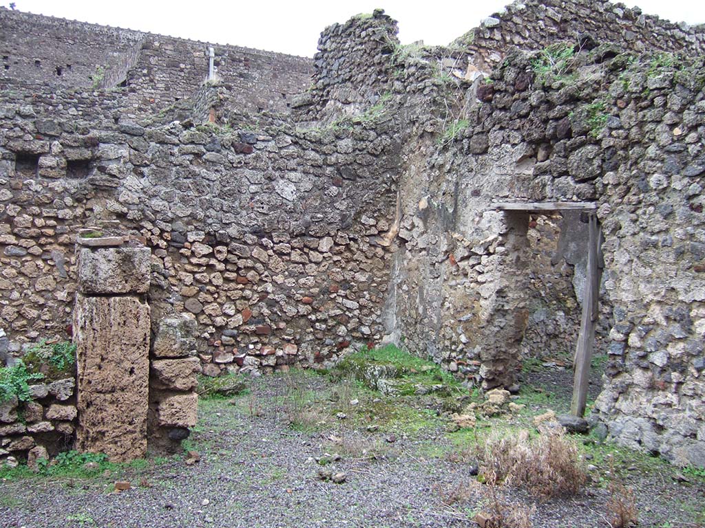 V.2.f, Pompeii. December 2005. Looking south-east across atrium. On the left would have been a cubiculum.
In the centre can be seen a room with remains of three masonry steps to an upper room above the cubiculum, and doorway to a small courtyard. 
According to NdS, on the black dado of the room with the stairs was a graffito  MID/
See Notizie degli Scavi di Antichit, 1896, (p.436).
See Mau in Bullettino dellInstituto di Corrispondenza Archeologica (DAIR), VIII, 1893, (p.7-9)
According to Jashemski, a terracotta dolium and several amphorae were found in the courtyard.
See Jashemski, W. F., 1993. The Gardens of Pompeii, Volume II: Appendices. New York: Caratzas, (p.112)

