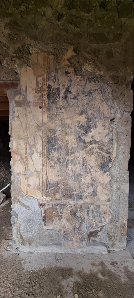 V.2.i Pompeii. December 2023. 
Looking east towards remaining decoration on wall between Oecus 21, on right, and Corridor 22, on left.
Photo courtesy of Miriam Colomer.

