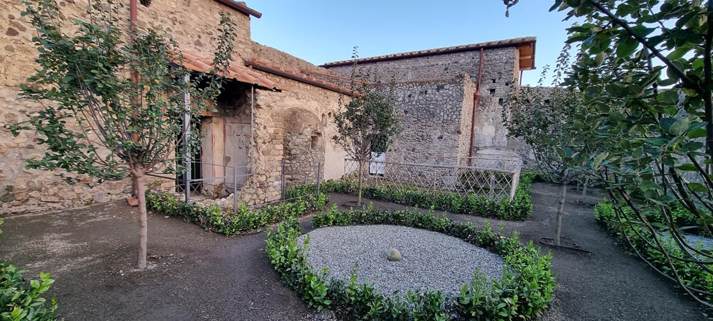 V.2.i Pompeii. December 2023. 
Room 12, garden area, looking south-east towards baths area with latrine, centre left. Photo courtesy of Miriam Colomer.
