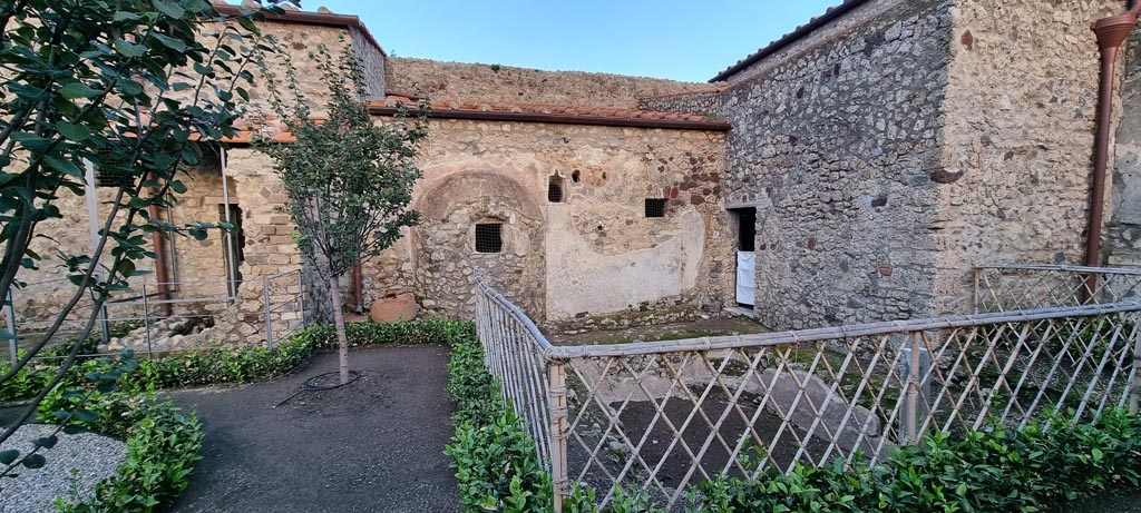 V.2.i Pompeii. December 2023. 
Room 12, looking east across garden area, with doorway to room 14, baths area, on right. Photo courtesy of Miriam Colomer.
