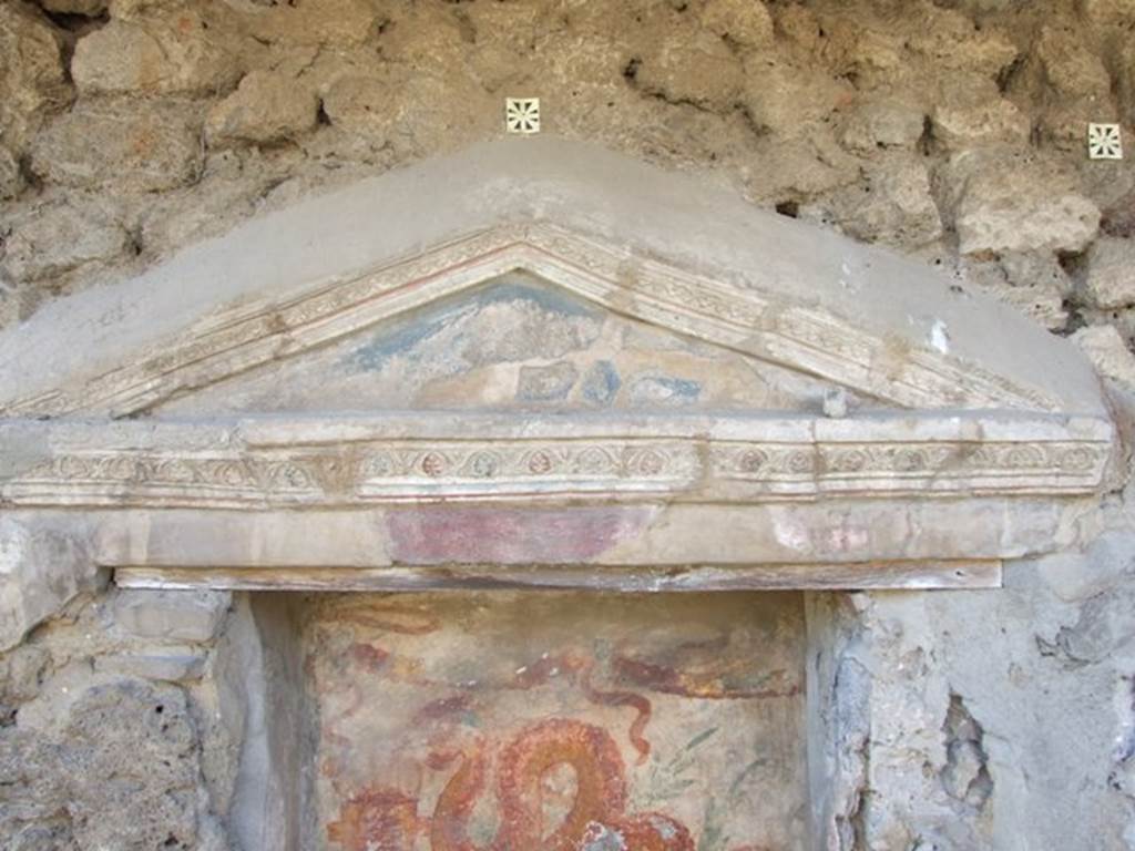 V.3.7 Pompeii. March 2009. West wall of garden area. Aedicula lararium pediment, with blue tympanum and decorative stucco. See Boyce G. K., 1937. Corpus of the Lararia of Pompeii. Rome: MAAR 14.  (112, p. 38, Pl 36, 2).