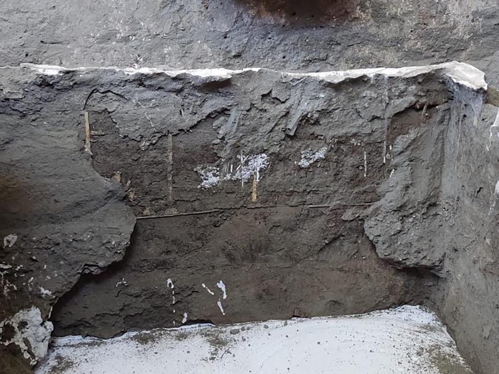 V.3.14 Pompeii. August 2022. Room 16. Letto 2.
Headboard with wooden panels decorated with relief squares, pertinent to the bed at the northwest corner.
Testata a pannelli lignei decorati con quadroni a rilievo, pertinenti al letto presso l’angolo nord-ovest.
Photograph © Parco Archeologico di Pompei.

