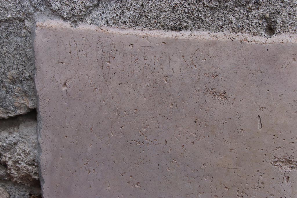 V.3 Pompeii. Casa del Giardino. October 2022. Graffiti from outside north (left) side of entrance doorway. Photo courtesy of Klaus Heese.