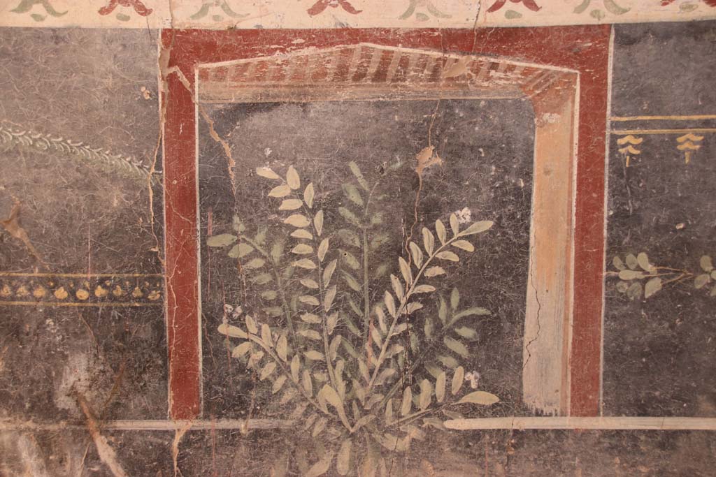 V.3 Pompeii. Casa del Giardino. September 2021.
Room 1, south wall, painted plant decoration on zoccolo at west end. Photo courtesy of Klaus Heese.