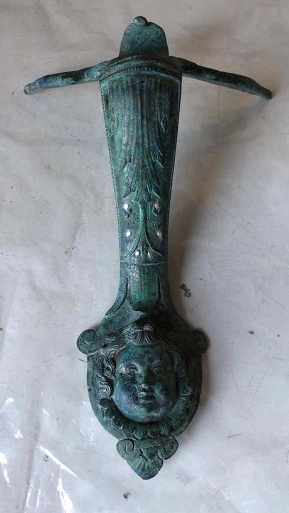 V.3 Pompeii. Casa del Giardino. 2018. Bronze handle with head and inset silver.
Maniglia in bronzo con testa e argento incassato.
Photograph © Parco Archeologico di Pompei.