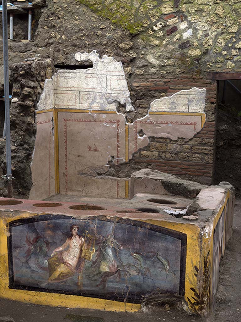 V.3 Pompeii, Thermopolium with painting of nereid. December 2020. Wall behind the counter decorated with panels bordered in yellow with imitation blockwork above.

V.3 Pompei, Termopolio con dipinto di nereide e anfore. Dicembre 2020. Parete dietro il bancone decorata con pannelli delimitati in giallo con imitazione di blocchi sopra.

Photo by Luigi Spina courtesy of Parco Archeologico di Pompei.

