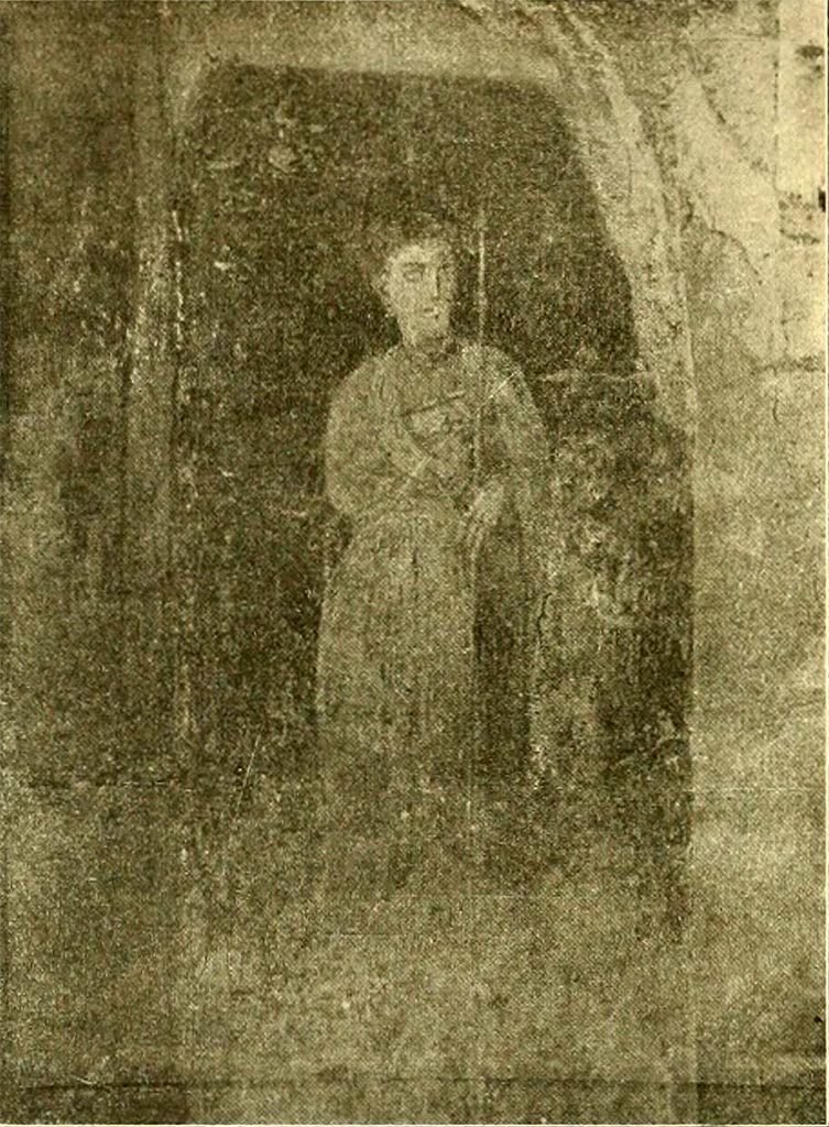 V.4.6/7 Pompeii. Painting of Venus Pompeiana with cupid. The background was red.
The goddess (0,66 high) with her hair gathered in a gold bonnet and diadem, adorned with pearl earrings, gold necklace, bracelets and rings on her fingers and wrapped in a light robe, has her right arm on her breast, and with the left she holds the rudder, leaning with her elbow on the shoulder of the cupid (0,39 high) who is next to her, decorated with a crown and wearing a green chlamys (fig. 5).
See Notizie degli Scavi di Antichità, 1899, p. 344, fig. 5.

