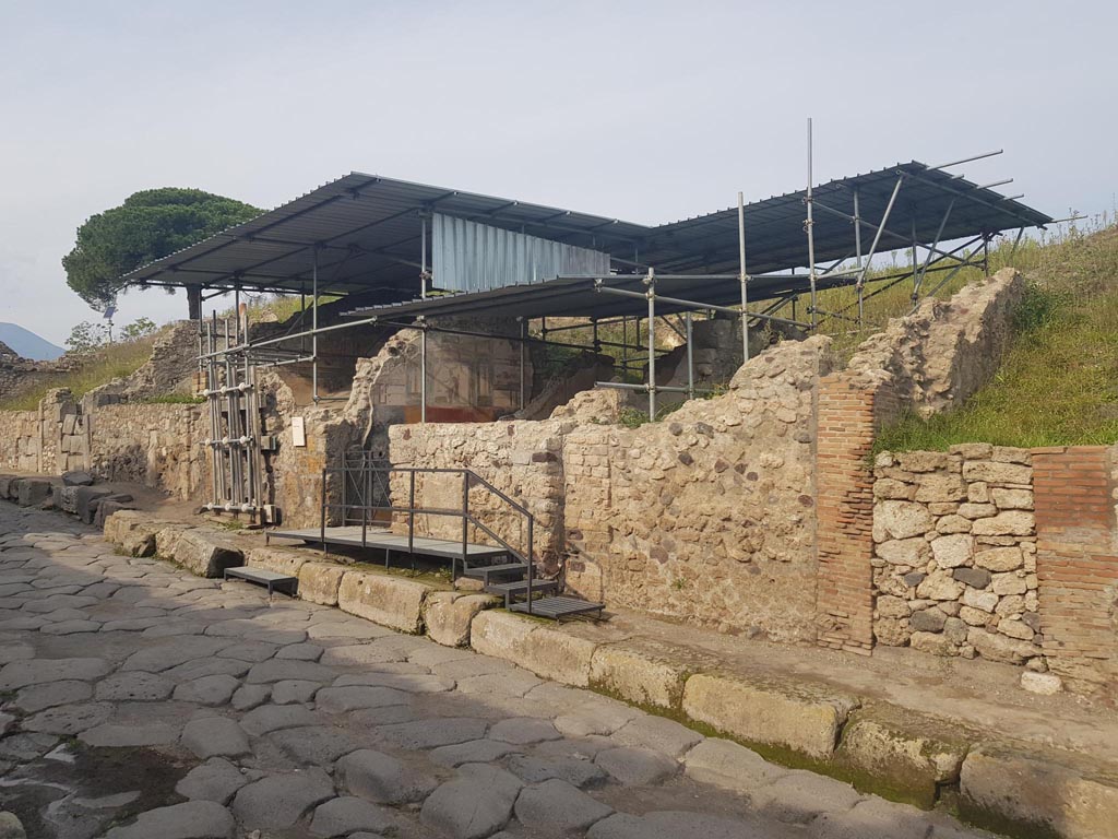 V.6.11 Pompeii, on right. October 2022. 
Looking north-east along Via del Vesuvio, with narrow entrance doorway to fauces 48, on right and the front wall of cubiculum 10 to its left. 
Photo courtesy of Klaus Heese.

