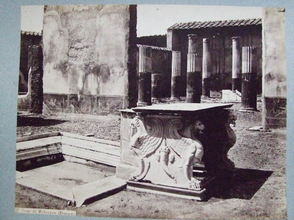 VI.9.2 Pompeii. Atrium 2 with impluvium 3 and table 6, looking north to peristyle 16. Old undated photograph, Courtesy of Society of Antiquaries. Fox Collection. The wall painting of Hephaestus and Thetis (below) would have been taken from the west end of the north wall (on left).
