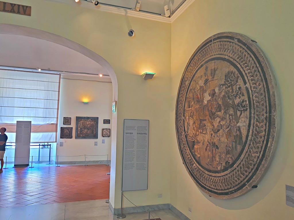VI.9.5 Pompeii. September 2024.
Looking across room in Naples Archaeological Museum with mosaic from triclinium 27, on right. Photo courtesy of Giuseppe Ciaramella.