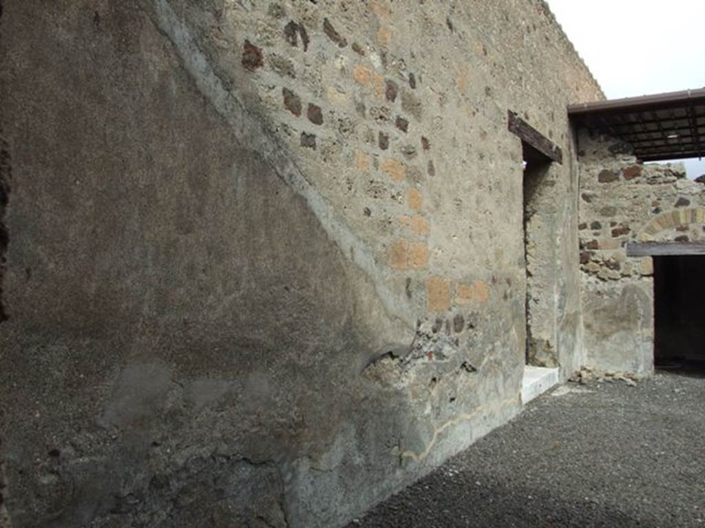 VI.9.7 Pompeii. March 2009. Room 2, north wall of atrium in north-east corner.  The doorway leading to peristyle 6 of VI.9.6 can be seen in the north wall, with the white threshold or step.
