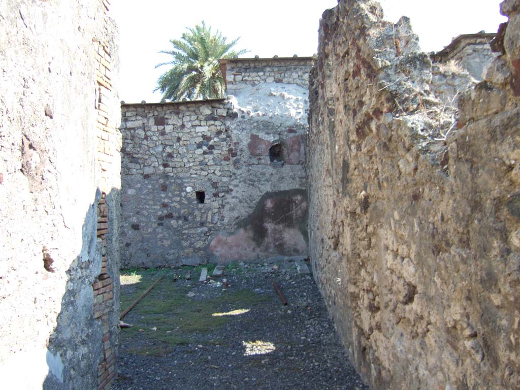 VI.11.12 Pompeii. September 2005. 
Looking south along unroofed walkway (19) towards south-west corner of garden area (7), along wide corridor of walkway.
The wall on the south side would join to VI.11.10 and the wall on the west (right) would join to VI.11.8.
According to Garcia y Garcia –
the same bomb that destroyed VI.11.8 also caused the destruction of several rustic rooms in the south of house VI.11.12.
These would have had their dividing walls to the south with VI.11.10, and to the west with VI.11.8.
In the 1980s he said, all the fallen structures were in total ruin and abandoned.
See Garcia y Garcia, L., 2006. Danni di guerra a Pompei. Rome: L’Erma di Bretschneider. (p.82).
