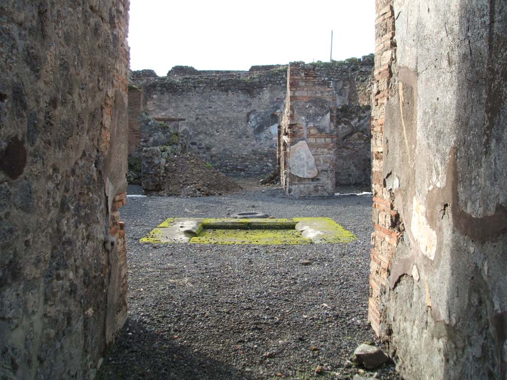 VI.13.10 Pompeii. December 2004. Looking west from entrance corridor across atrium and impluvium.
According to Garcia y Garcia, at the head of the impluvium was a masonry table with an arch below.
This suffered damage to its top, when the bomb fell on the area of the house at VI.13.9, in 1943.
See Garcia y Garcia, L., 2006. Danni di guerra a Pompei. Rome: L’Erma di Bretschneider. (p.87 and figs 186 and 187)
Fig 187 shows the table, photographed by Tatiana Warscher after the war.
It appears to have suffered a further loss and is now no longer there!