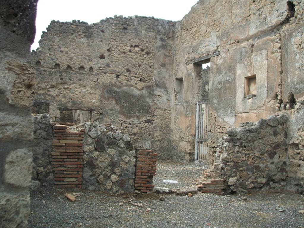 VI.14.19 Pompeii. May 2005. Looking west towards VI.14.18 and VI.14.20.
According to Boyce, in the north wall of the main room (of VI.14.18/19) is a rectangular niche, set 2.10 m above the floor.
See Boyce G. K., 1937. Corpus of the Lararia of Pompeii. Rome: MAAR 14. (p.52, no.199, with Pl.1, 2) 
