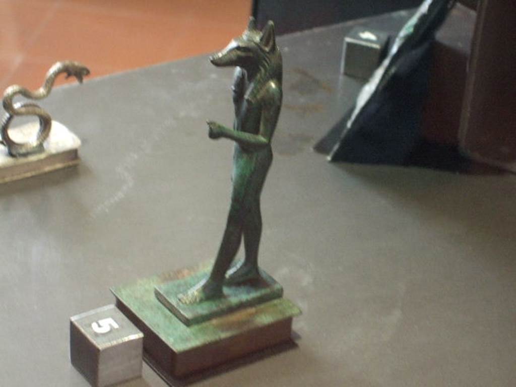 VI.14.27 Pompeii Found in room “b”, a bronze statuette of the dog faced Egyptian god Anubis.
Now in Naples Archaeological Museum. Inventory number 110606.
