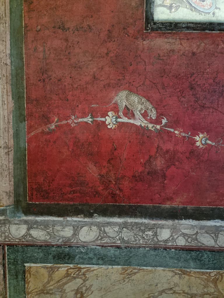 VI.15.1 Pompeii. December 2023. 
South wall of exedra, detail of painted decoration below central panel. Photo courtesy of Miriam Colomer.
