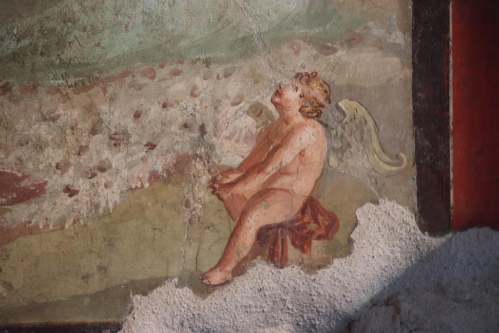 VI.15.1 Pompeii. October 2023. 
Central wall painting from south wall, detail of Cupid from right (west) side. Photo courtesy of Klaus Heese.
