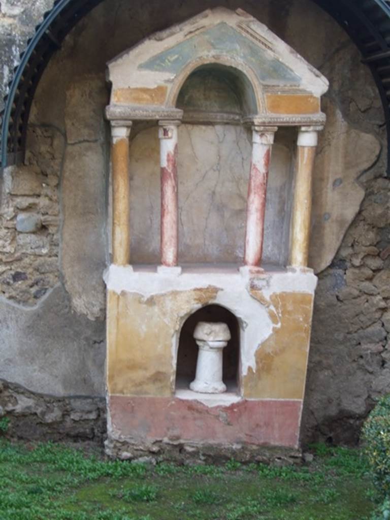 VI.15.8 Pompeii. December 2007. Household shrine in the garden.
According to Boyce, against the west wall of the garden stands an aedicula. It was built upon a high masonry podium coated with yellow stucco. The aedicula is formed by four columns, and two antae applied to the rear wall. These support a roof with pediment. The columns are coated with stucco and painted, the two outer being yellow, the two inner red. The rear wall of the shrine was painted white, as if for a painting but no trace remains. The base is adorned with a red dado and in the centre is cut a large arched recess, painted red within. See Boyce G. K., 1937. Corpus of the Lararia of Pompeii. Rome: MAAR 14. (p.55, np.214, Pl.32,2)
See Giacobello, F., 2008. Larari Pompeiani: Iconografia e culto dei Lari in ambito domestico. Milano: LED Edizioni. (p.276)
See Warscher, T., 1925. Pompeji: Ein Führer durch die Ruinen. Berlin und Leipzig: de Gruyter. (p.92)