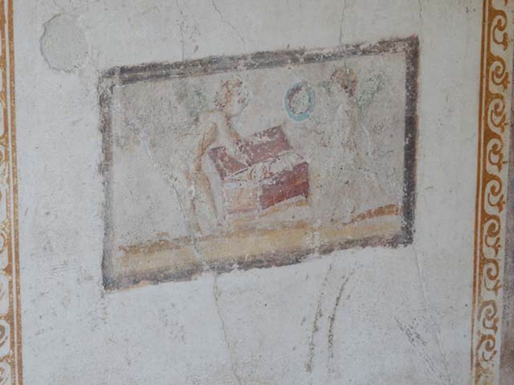VI.15.8 Pompeii. May 2015. East wall of summer triclinium showing small painted panel of cupids and a chest. Photo courtesy of Buzz Ferebee.
