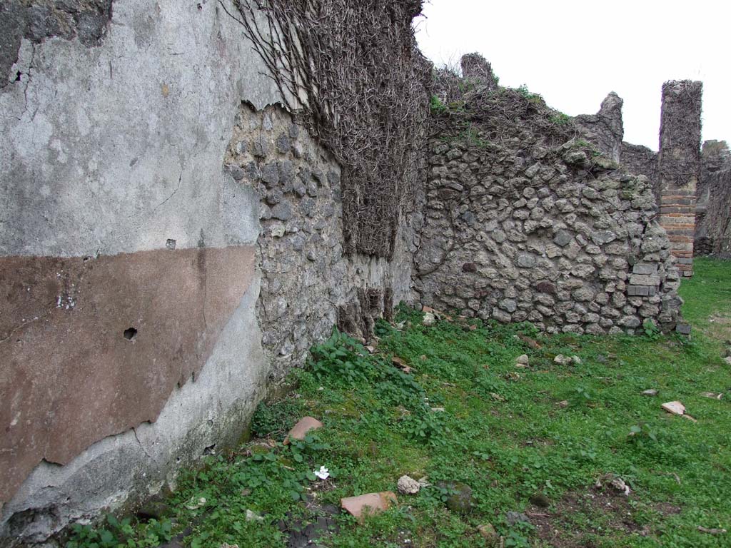 VI.16.10 Pompeii. December 2007. South side of shop, with remains of faded white plastered wall and high red dado.