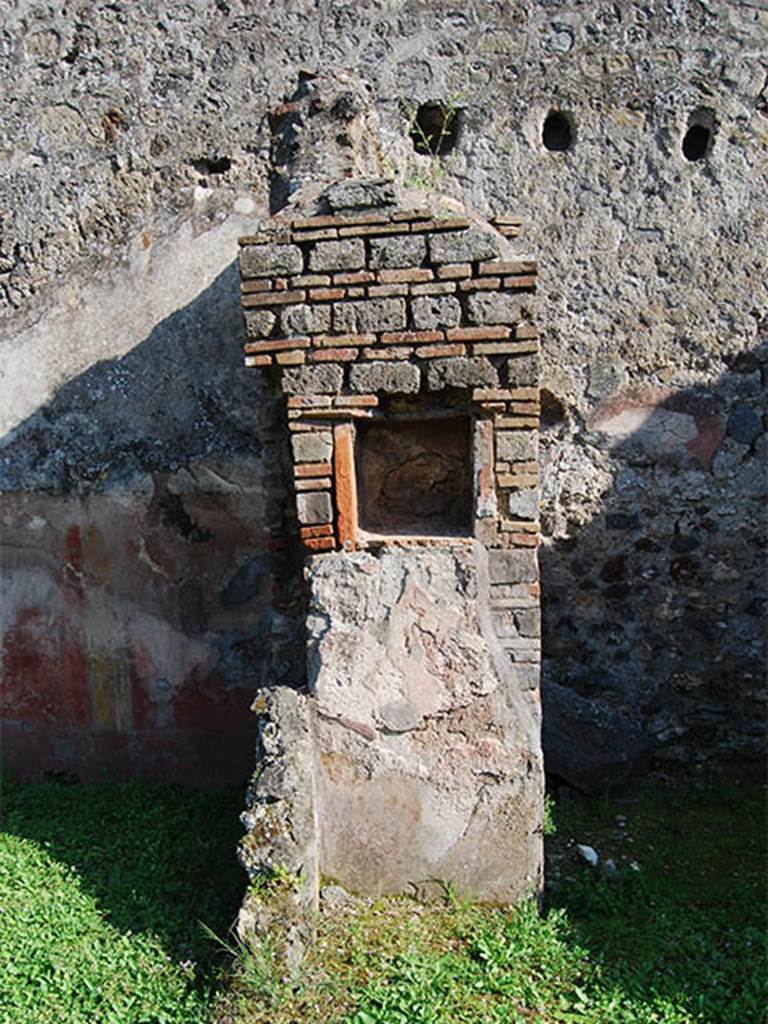 VI.16.21-22 Pompeii. May 2014. Pillar with square niche. Photo courtesy of Paula Lock.
In the north face of the pilaster, built into the east wall of the next room, was the lararium niche on a red background, around and below which were the painted serpents.