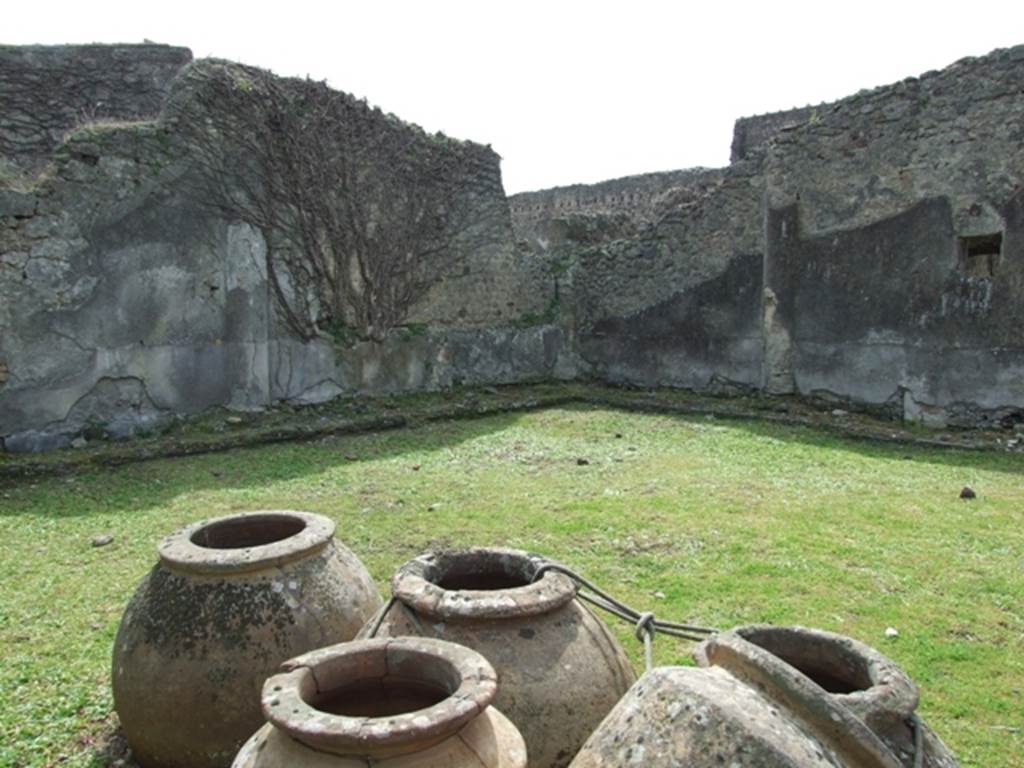 VI.16.27 Pompeii. March 2009. Looking south-west across peristyle garden M. According to NdS, in the north-east corner of the garden area was a group of terracotta pots, fixed into the soil. They consisted on three large spherical dolii, two others somewhat smaller with cylindrical bodies of the type seen in the sales counters of thermopolii, the sixth was of the same type but very much smaller. Two of the three large earthenware jars were broken and had been reattached with lead by the ancients. The third of the large dolii, had a number incised onto its belly – XVII. See Notizie degli Scavi, 1908, (p.190)