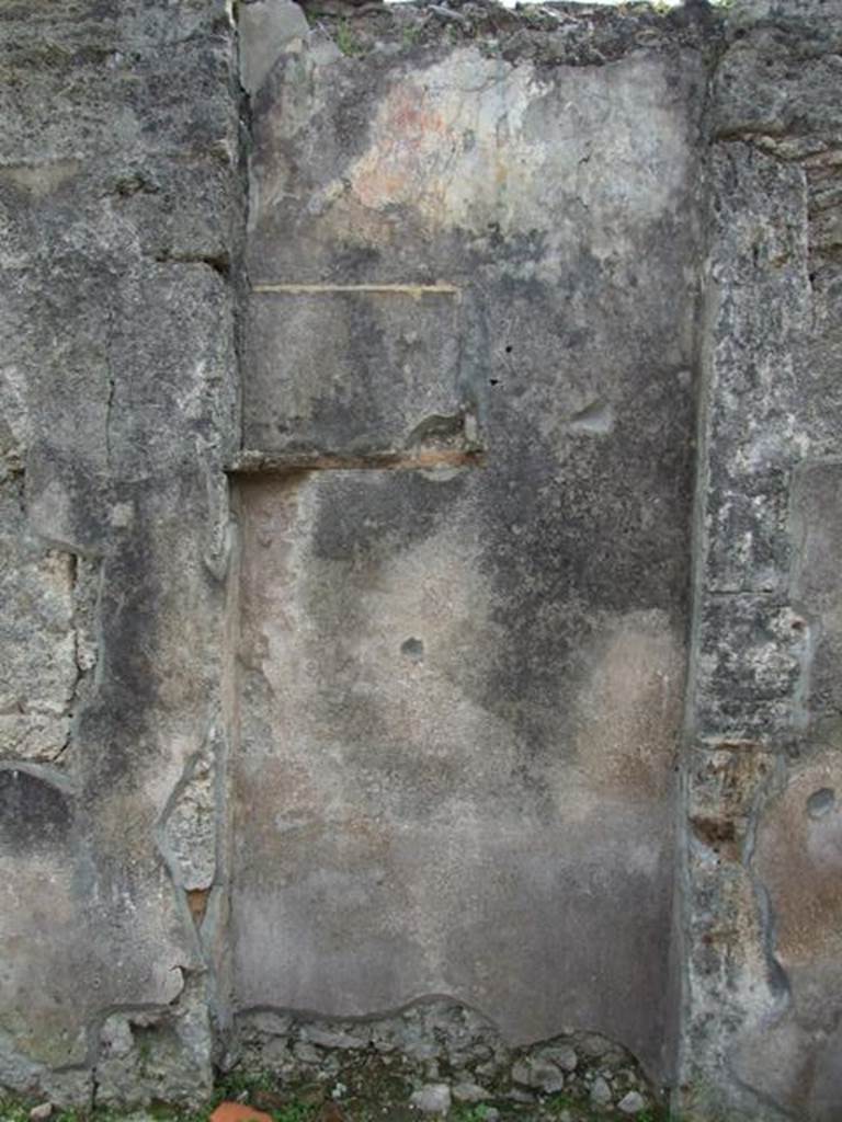 VI.16.27 Pompeii. March 2009. Room B, recess in south wall of atrium.
According to Boyce, the doorway that led from the atrium to the peristyle was walled up, leaving a shallow recess in the south wall.
Within this recess, in the upper left corner, a white panel was marked off by green stripes on both sides. The figure of Jupiter was painted on the panel. He was seated upon a throne, leaning his forehead against his left hand, through the bend of this arm passed a long sceptre.
The lower end of the sceptre rested on the ground., in his right hand he held the thunderbolt. His feet were placed on a footstool and to its left stood an eagle. In the wall below the panel were embedded two broken tiles, one horizontal, the second perpendicular to the first at its west end. The wall space between the painting of Jupiter and the two tiles was decorated with plants painted on a yellow background. The horizontal tile may have served as a shelf for offerings, but the purpose of the two tiles was not clear. Found near the shrine was a terracotta votive altar. Not. Scavi, 1908, 184. See Boyce G. K., 1937. Corpus of the Lararia of Pompeii. Rome: MAAR 14. (p.59, no.226)