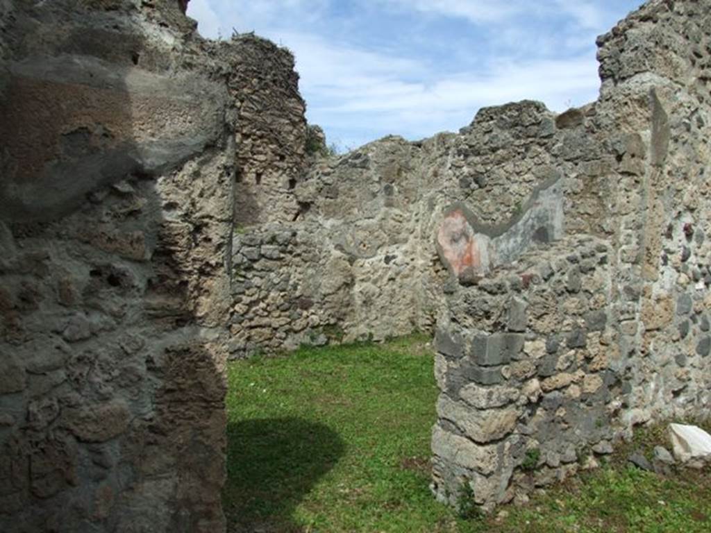 VI.16.32 Pompeii. March 2009. Looking north to doorway to room E, oecus, with remains of window on right. The floor of this room was cocciopesto with marble inlay. The walls were painted with the usual large panels, three on each of the narrow walls (east and west). The panel remains on the south wall, were three but the doorway and window also opened in this wall. The north wall would have certainly had more than three panels, but its plastered decoration was entirely destroyed. The frieze was also almost entirely destroyed.  The plinth had a black background, and was divided in panels using dashes.  The large panels of the walls had a red background.  The central panel on the east and west wall contained a white background.  In the centre of the other panels on the same walls was a painting of a small pot or vase, with a few small secondary objects below. In the middle of the preserved panel of the other two walls was a feeding bird, except in that to the left of the window where there was a painted vase.
