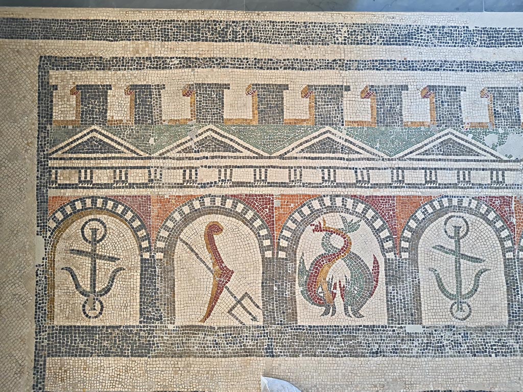 VI 17.10 Pompeii ?. June 2024.  
Detail from mosaic of “doors”, starting with an anchor, trident, two dolphins, an anchor, one dolphin, and a stern of a ship with rudder. 
On display in Naples Archaeological Museum, Room CXXXIV.  Photo courtesy of Giuseppe Ciaramella. 

