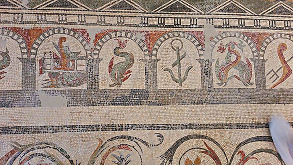 VI 17.10 Pompeii? July 2019. 
Detail from mosaic of “doors”, starting with a stern of a ship with rudder, a dolphin, and anchor, two dolphins, and a trident. 
On display in Naples Archaeological Museum. Photo courtesy of Giuseppe Ciaramella.
