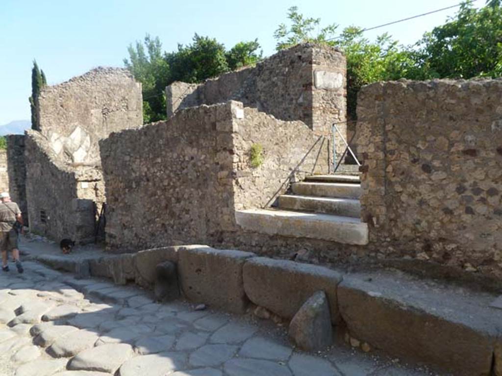 VI.17.10 Pompeii. May 2011. Looking south-west on Via Consolare towards raised pavement outside of entrance steps and doorway. Photo courtesy of Michael Binns.