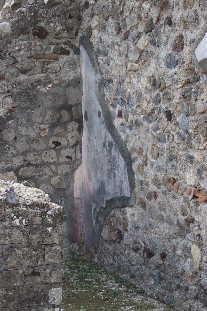 VI.17.10 Pompeii. September 2015. South side of atrium, with two of the three doorways to cubicula.  According to Allroggen-Bedel – 
The room described by La Vega, as No.10, corresponded to the preserved remains in the middle room left from atrium, doorway on right of photo. 
According to La Vega – 
“From the 9th to the 17th November we excavated this room, which had a floor of black mosaic with white border all around, and white rosettes sprinkled throughout, and it was found patched up by the ancients at a site close to the threshold. The plaster was painted with following format: Red zoccolo with a few lines, and large fronds of herbs, the panels above were yellow with vases/pots in the middle, the bands that one could distinguish were red, decorated with grotesque architecture: the decoration above had a white background with various bands and grotesque architecture. On one side of this room, there was in the wall, an undercut recess that ends with the floor. It was preserved without lifting a piece. (Si e conservato senza levarci alcun pezzo).”
