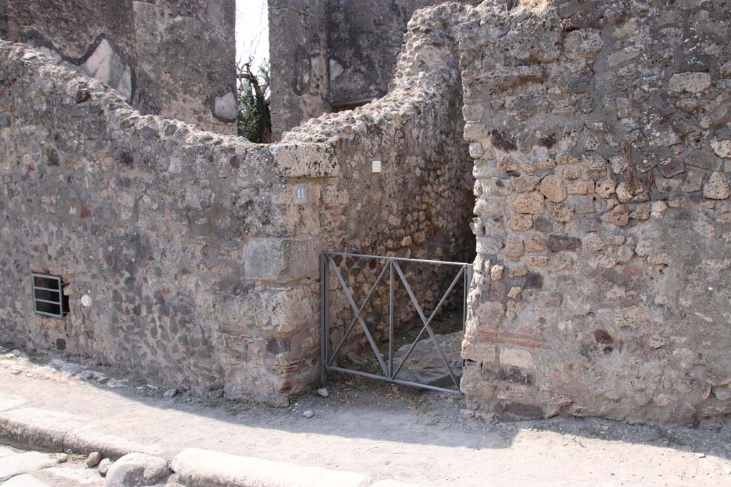 VI.17.11 Pompeii. September 2021. Looking south-west towards entrance on Via Consolare. Photo courtesy of Klaus Heese.
On the left of the entrance would be the underground area of VI.17.12, with the triclinium of VI.17.13, above it.
See comment in VI.17.13, repeated below -
According to Allroggen-Bedel, she could not locate rooms 11 and 12 of VI.17.10, but, she wrote -
However two rooms in the next door house (VI.17.12-13) meet the description of rooms nos. 11 and 12.
La Vega said that in the space described as no.12, he had discovered a sotterraneo (underground room/cellar, etc). 
The characteristics of the rooms bed recess and sotterraneo, were both to be found next to the cellar stairs in VI.17.12.
The room described as no.11 is probably identical with the room next door (VI.17.13), where the remains of the yellow background central zone decorations  were preserved.
See Allroggen-Bedel - Die malereien aus dem Haus Insula Occidentalis 10, in Cronache Pompeiane II, 1976 (p.144-183).
