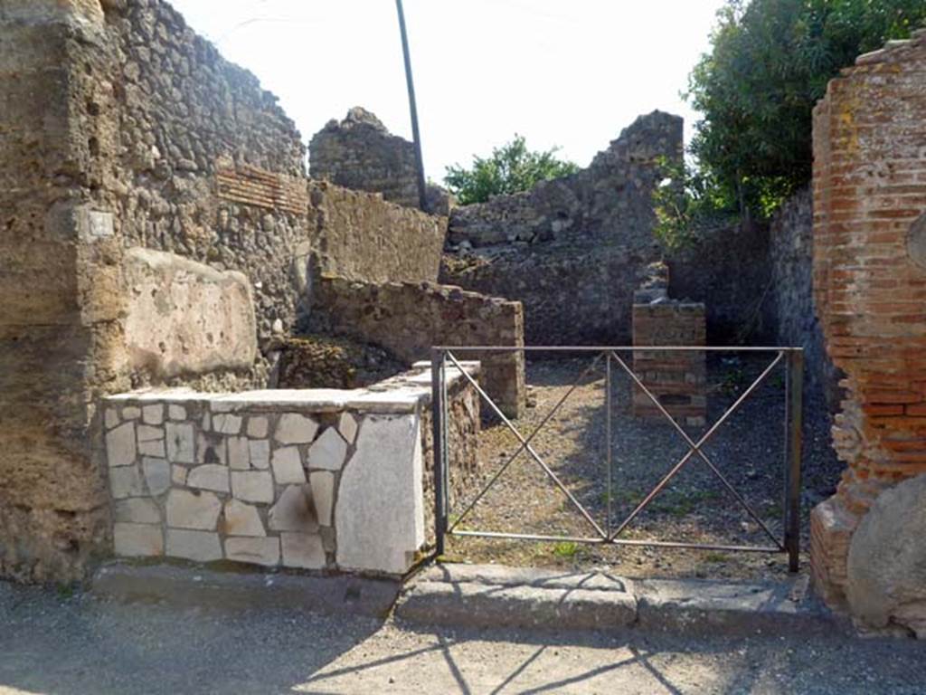 VI.17.31 Pompeii. May 2011. Looking west to entrance doorway. Photo courtesy of Michael Binns. According to Fiorelli 
Una taberna attigua allindicato edifizio, faceva parte del caseggiato che fa seguito. Ha il podio per la vendita, la bocca della cisterna, la scaletta dellammezzato, e nel fondo due celle per gli avventori.
See Fiorelli, G. (1875). Descrizione, (p.434)
See Pappalardo, U., 2001. La Descrizione di Pompei per Giuseppe Fiorelli (1875). Napoli: Massa Editore. (p.159)
(translation  "A bar adjacent to the designated building, which was part of the house that followed. It had a sales podium/bench, a cistern-mouth, the stairs up to the mezzanine, and at the rear two rooms for the customers. "

