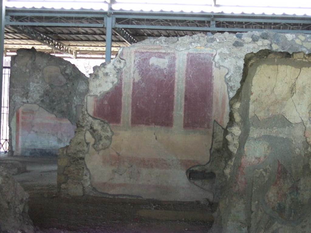 VI.17.41 Pompeii. May 2006. Painted east wall in ala on south side of atrium. According to PPM, this wall was partially cut away during the Bourbon excavations. It was painted with a podium of yellow and red bands, the middle zone had purple panels separated by green pilasters. 
