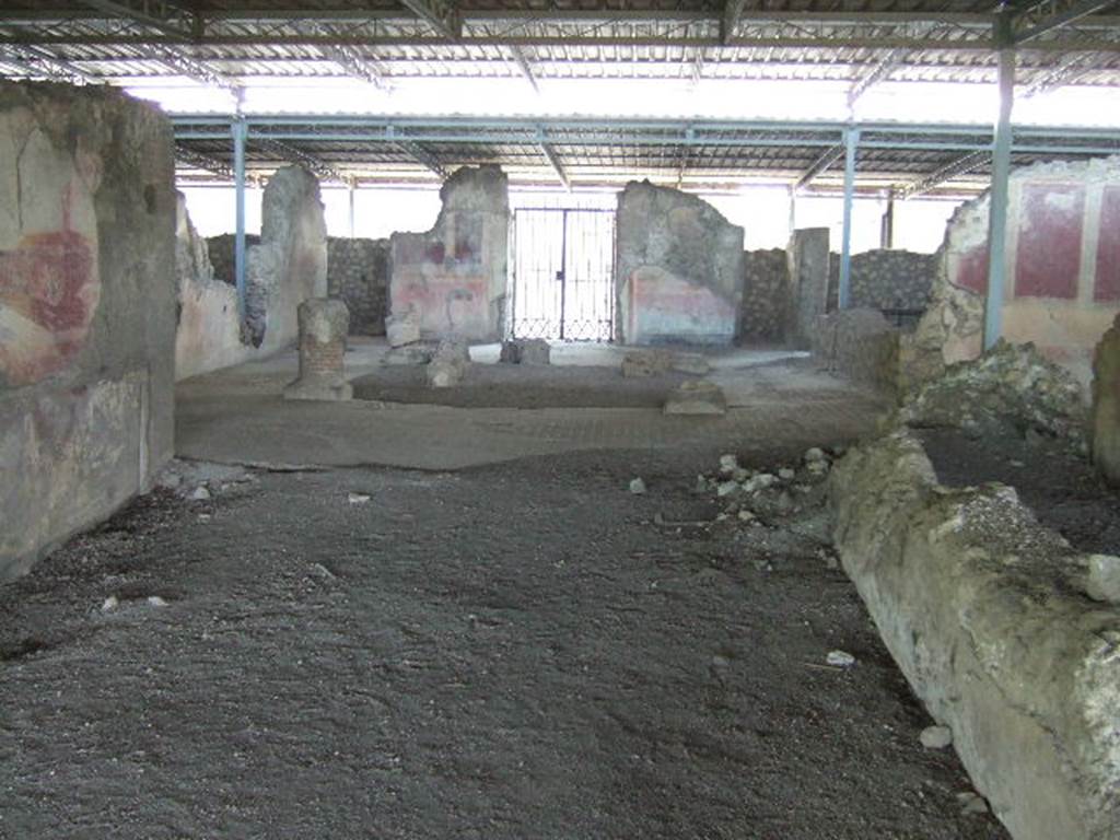 VI.17.41 Pompeii. May 2006. Looking east from rear of tablinum towards atrium and entrance.
According to PPM, this room has been very badly preserved, it was damaged during the Bourbon excavations when the south wall of the neighbouring room was cut away, and was possibly deprived of its mosaic floor at that time.
On the north wall, the only wall that retains any decoration, the zoccolo was red and in it, in the centre of the wall a female figure can be seen.
In the middle area of the wall, resting his right foot on the base of a podium was a huge figure and nearby the bow of a ship. 
The zoccolo appeared to be more sunken into the wall than the rest of the wall, and with its sharp break from the painting of the middle area, may have been of an earlier wall decoration.
