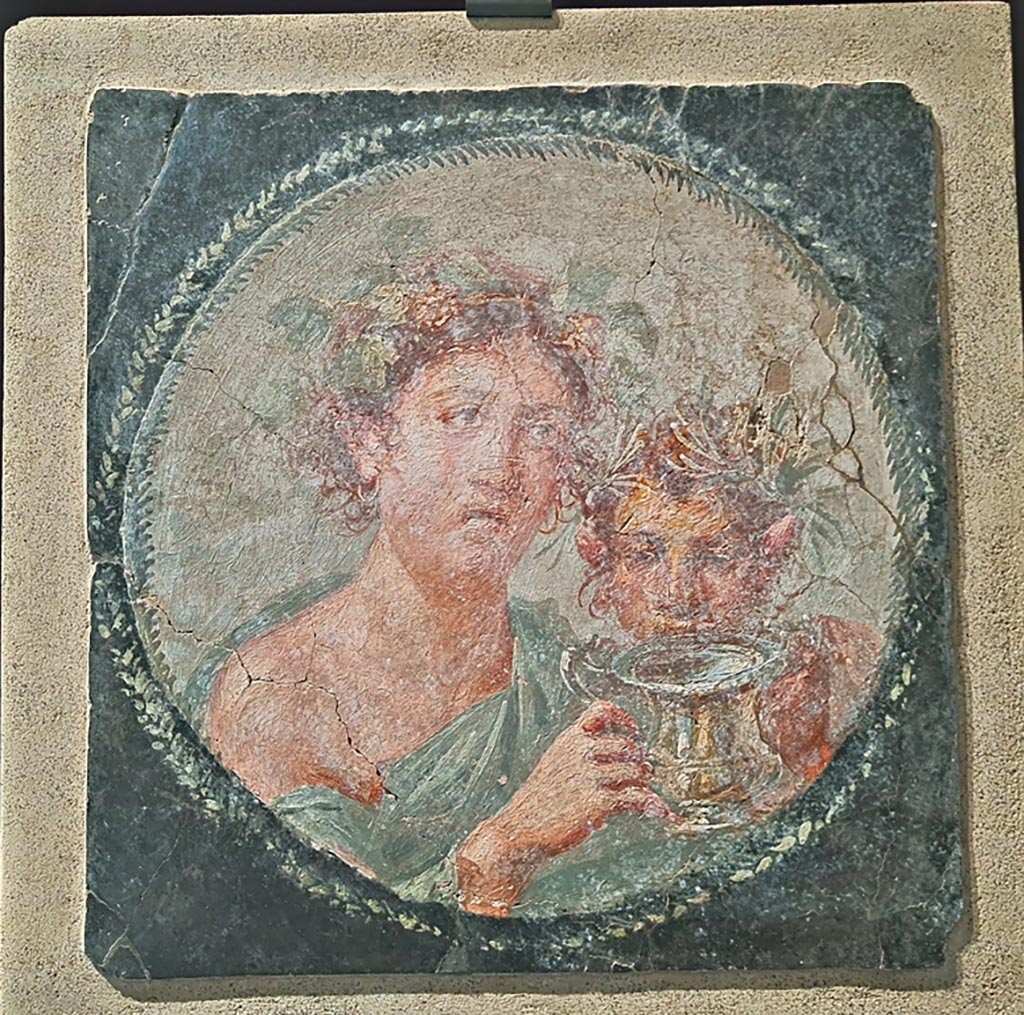 VI.17.42 Pompeii. April 2022.
Medallion depicting Maenad and a young Satyr, from west end of the north wall of the large triclinium. On display in exhibition in Palaestra.
Photo courtesy of Giuseppe Ciaramella.